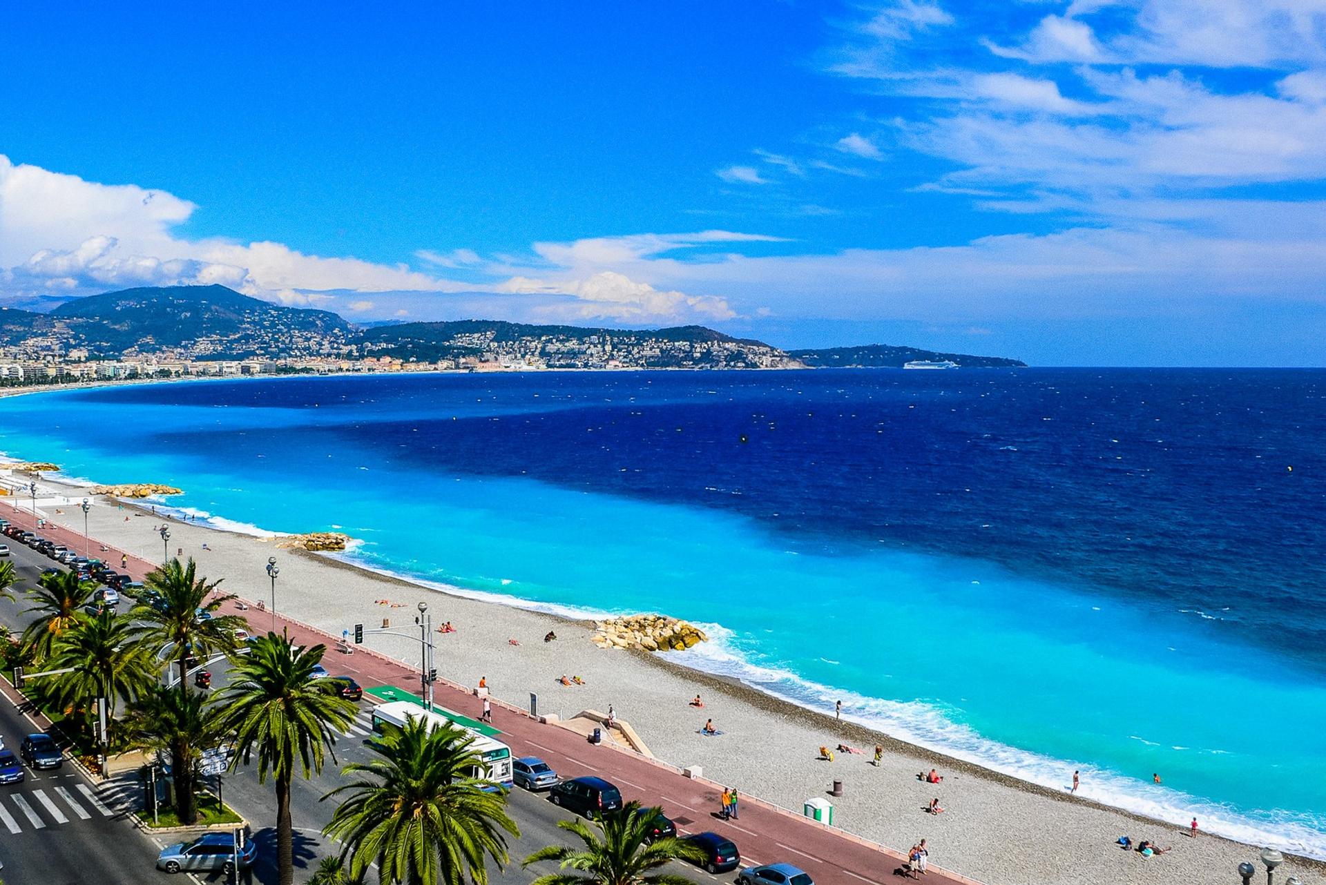 Beach with turquise water in Nice on a sunny day with some clouds