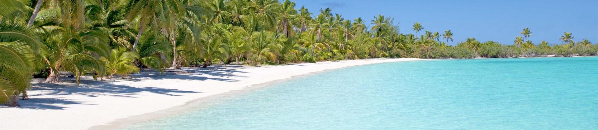 Nice beach by the sea with turquise water in Aitutaki on a clear sky day