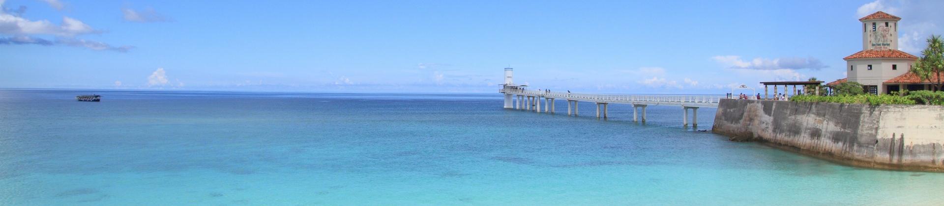 Nice beach by the sea and port near Nago in sunny weather with few clouds