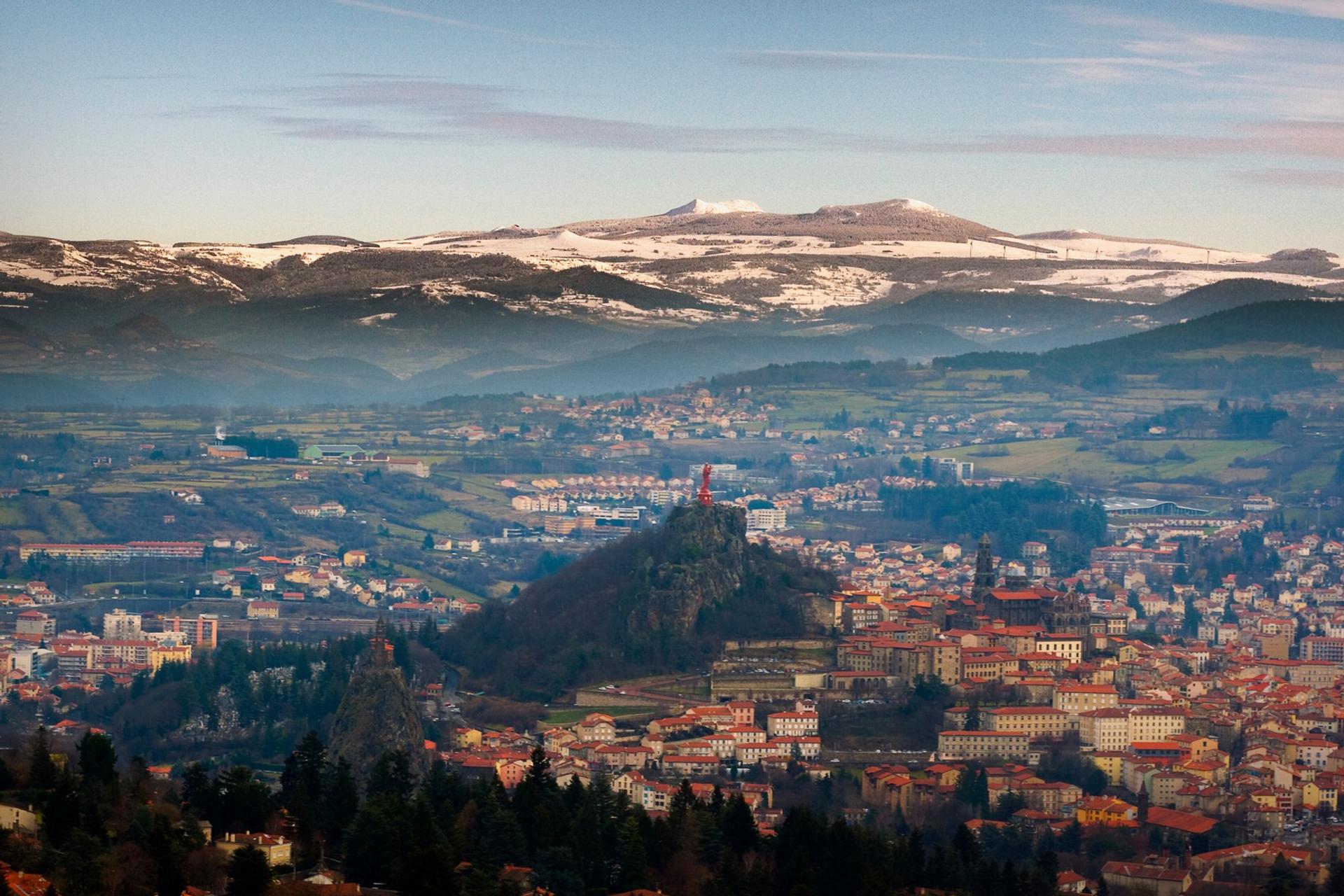 Aerial view of mountain range in Le Puy-en-Velay in sunny weather with few clouds