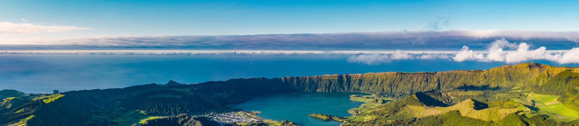 Aerial view of mountain range in Azores in sunny weather with few clouds