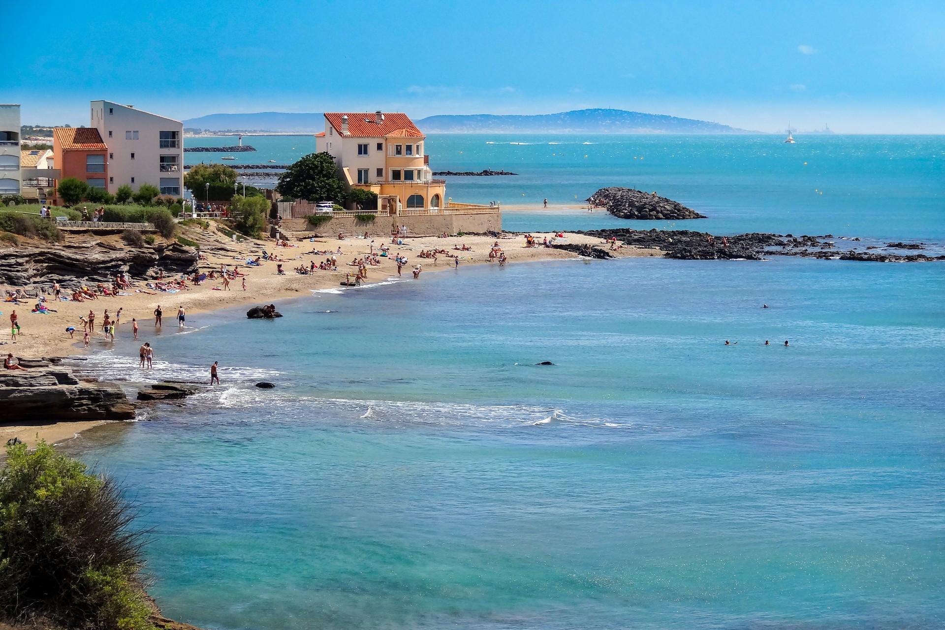 People on the beach and lake in Agde on a sunny day